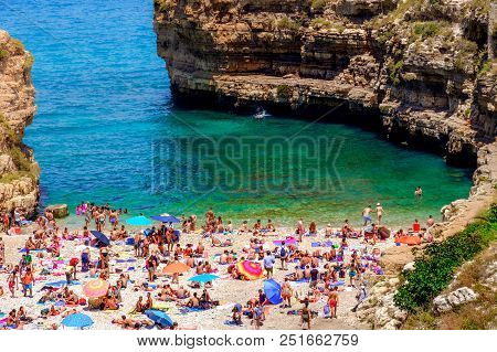 Polignano A Mare, Italy, 13 Lug 2018 - Holiday Makers At The Small Sea Lagoon Beach Of Polignano
