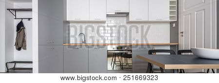 Panorama Of Open Kitchen In Gray And White With Simple Table