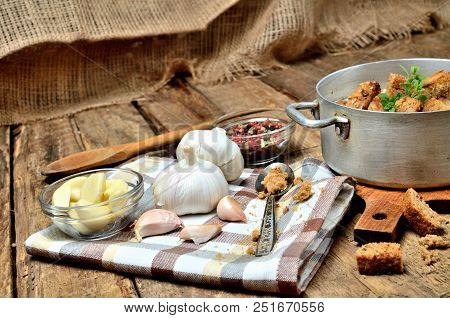 Close-up Garlic Soup In An Old Saucepan, Fresh Garlic Bulbs, Cloves, Colored Pepper, Wooden Spoon, C