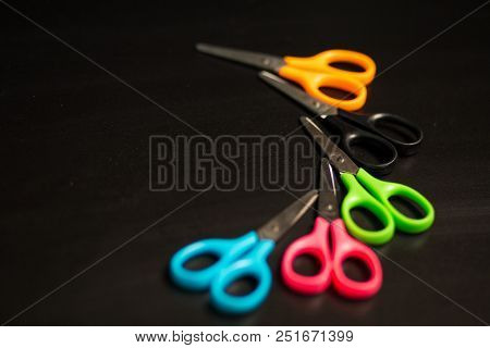 Many Multicolored Scissors Isolated On Black Table