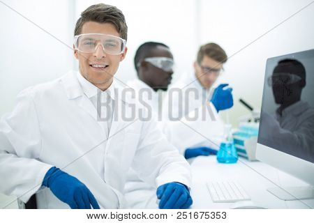 modern scientist sitting in front of a computer monito