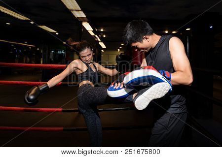 Girl Doing Kick Exercise During Kickboxing Training With Personal Trainer