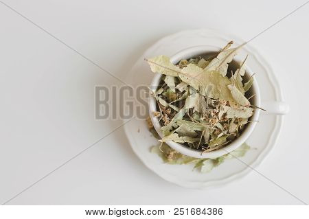 Dried Lime Tree Flowers And Leaves In A White Cup, Herbal Drink. Healthy Tea