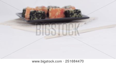 Different Types Of Maki Sushi On A Black Plate.isolated On White Background