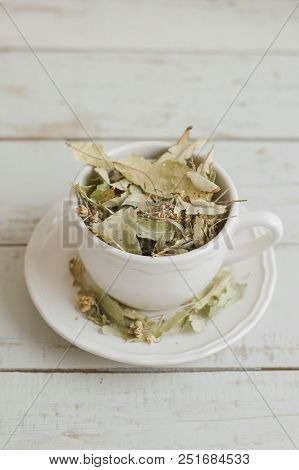 Vertical Photo Of Dried Lime Flowers In A White Tea Cup. Herbal Drink. Healthy Tea