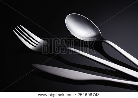 Set Of Stainless Steel Cutlery On A Black Reflective Background, Restaurant Concept