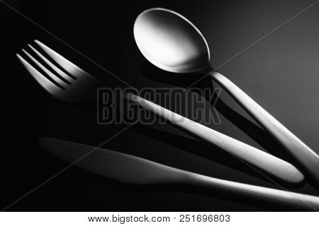 Set Of Stainless Steel Cutlery On A Black Reflective Background, Restaurant Concept