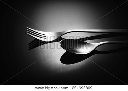 Set Of Stainless Steel Cutlery On A Black Reflective Background, Restaurant Concept
