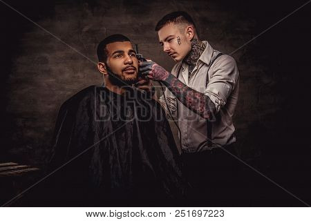 Old-fashioned Professional Tattooed Hairdresser Does A Haircut To An African American Client, Using 