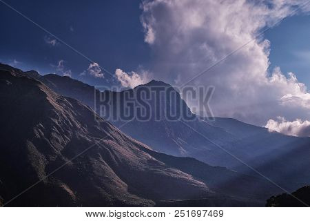 The Rays Of The Sun Fall On The Mountains In The Clouds Against The Sky