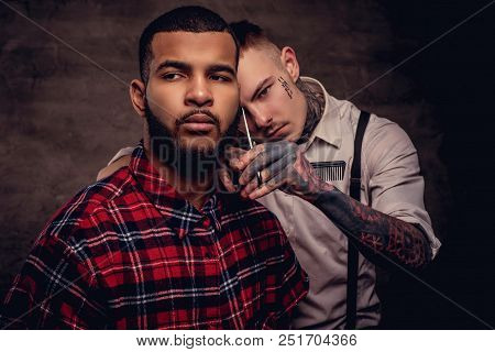 Bearded African American Hipster Guy In A Fleece Shirt Getting A Haircut By An Old-fashioned Profess