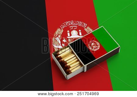 Afghanistan Flag Is Shown In An Open Matchbox, Which Is Filled With Matches And Lies On A Large Flag