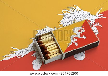 Bhutan Flag  Is Shown In An Open Matchbox, Which Is Filled With Matches And Lies On A Large Flag.