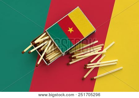 Cameroon Flag  Is Shown On An Open Matchbox, From Which Several Matches Fall And Lies On A Large Fla