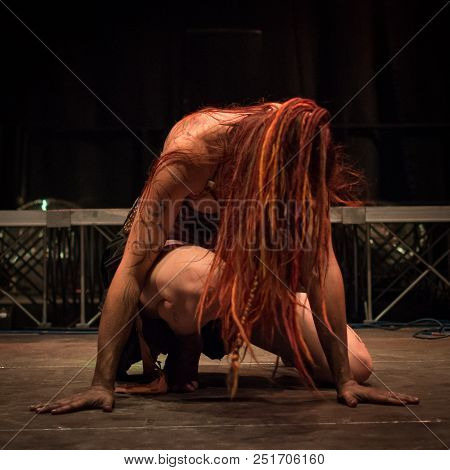 Tribal Dancer With Long Red Hair Crouched On The Stage, Square Image