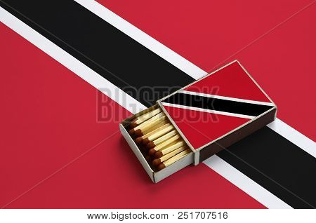 Trinidad And Tobago Flag  Is Shown In An Open Matchbox, Which Is Filled With Matches And Lies On A L