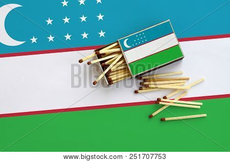 Uzbekistan Flag  Is Shown On An Open Matchbox, From Which Several Matches Fall And Lies On A Large F