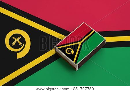 Vanuatu Flag  Is Pictured On A Matchbox That Lies On A Large Flag.