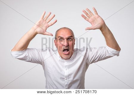Mature Hispanic Man Is Happy With His Win. He Is Holding His Fists And Shout Wow. Sign Of Victory Is