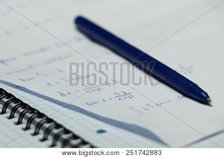 A Blue Pen With Small Exercise Book And Different Make A Calculation In Math On University. A Small 