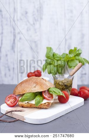Salad Caprese In Fresh Bread And Pesto Sauce For Lunch. A Breakfast Sandwich With Basil And Mazarell