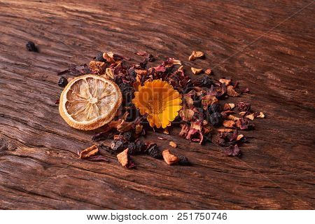 Black Dry Fruit Tea Leaves On Wooden Table. Selective Focus