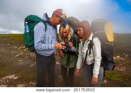 Travel Lifestyle And Survival Concept Rear View. Hiking Man And Women With Backpack Enjoys A Hike  A