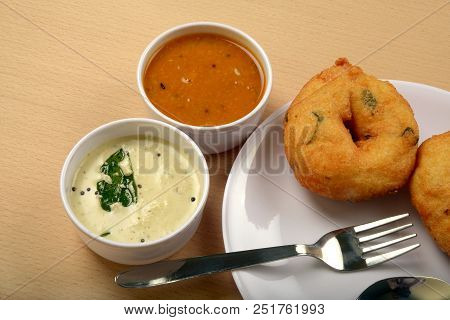 Sambar vada or Medu vada is a very popular South Indian food on wooden background