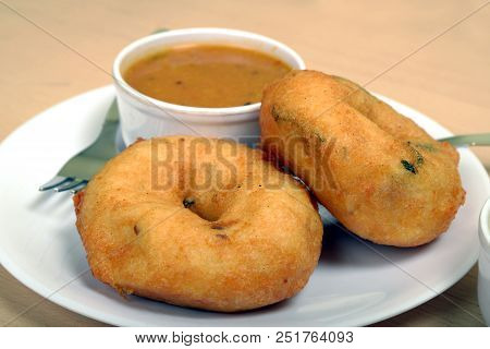 Sambar vada or Medu vada is a very popular South Indian food on wooden background