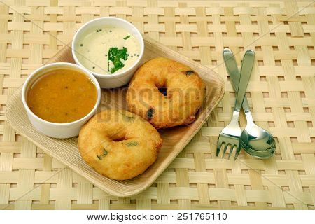Sambar vada or Medu vada is a very popular South Indian food on wooden background