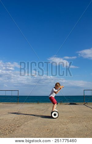 Child On Hover Board. Kids Riding Scooter In Summer Near The Sea. Balance Board For Children. Electr