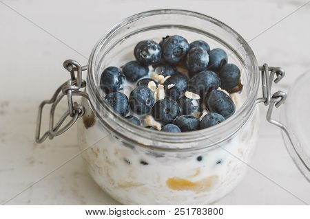 Overnight Oats With Bluberry Soaked In Coconut Milk In A Glass Jar. Vegan Friendly Breakfast. Oatmea