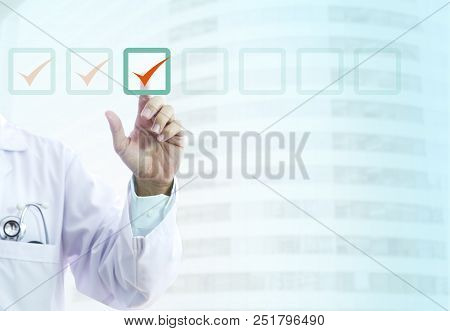Hand Of A Male Doctor In Light-blue Shirt And White Gown Ticks Into Virtual Checklist Items Indicate