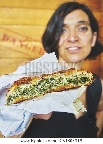 Greek Woman Eating A Traditional Spanakotiropita, Spinach And Feta Pie.