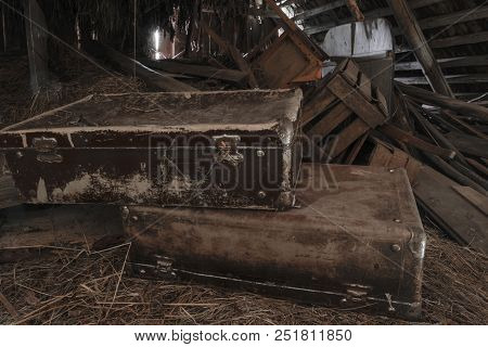 Two Old, Rusty, Dusty And Dirty Suitcases Lying In Attic On Hay Straws