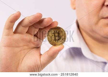 Golden Bitcoin In A Man Hand, Digitall Symbol Of A New Virtual Currency On White Background