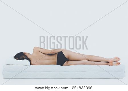 Young Bare Woman Lying On Orthopedic Mattress. Isolated On White Background. Healthy Concept.