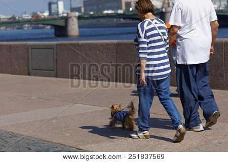 ST. PETERSBURG, RUSSIA - JULY 29, 2018. People with dog worn in telnyashka, the iconic uniform garment of Russian Navy, on the embankment of Nevka river during Navy Day celebrations
