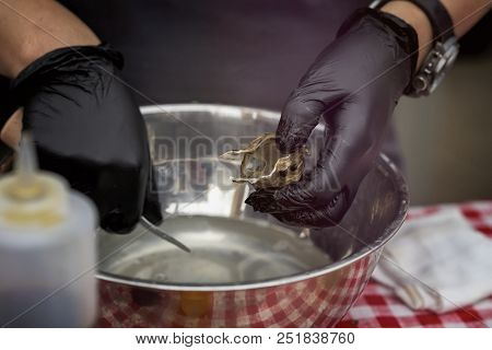 Shucking Fresh Oysters, Man's Hands In Black Gloves With Knife And On A Seafood Market. Gastronomic 