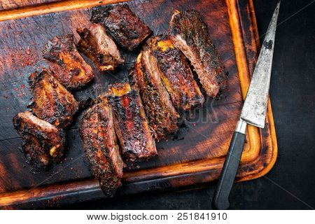 Modern barbecue dry aged wagyu flank steak sliced with green asparagus and fresh berries as top view plate 