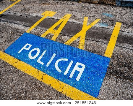 Yellow Taxi And Blue Policia Parking Signs On The Asphalt In The Spanish City Of Palma De Mallorca