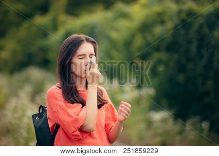 Girl Suffering From Asthma Using Her Inhaler Outdoors