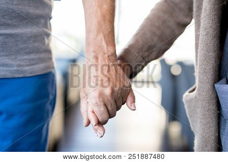 Close up of unrecognizable senior couple holding hands., symbol of love and longevity