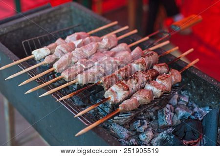 Food and leisure concept - grilling shashlik on a barbecue skewer