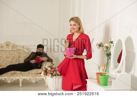 Planting Concept. Sensual Woman With Gardening Tool For Planting And Man Reading On Sofa. Planting A