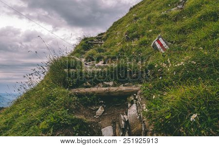 Scary Hiking Path On A Steep Mountain. Hiking Path Sign On A Stone In The Grass, Brienzer Rothorn Sw