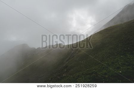 Scary Hiking Path In The Fog On Steep Mountain. Hiking Path Through Grass, Brienzer Rothorn Switzerl