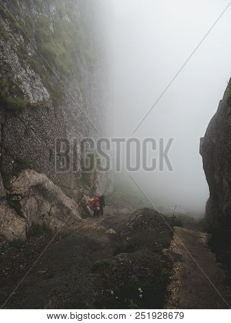Two People Walking Up A Steep Mountain Hiking Path Covered In Fog And Rain, Swiss Alps Brienzer Roth