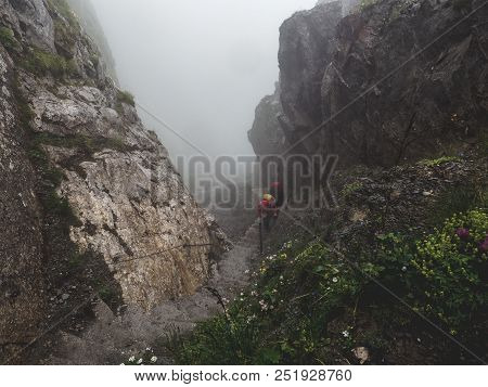 Two People Walking Up A Steep Mountain Hiking Path Covered In Fog And Rain, Swiss Alps Brienzer Roth