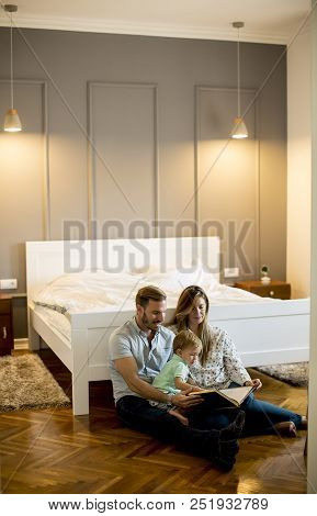 Parents Reading Book To Little Boy And Have Fun On The Floot In The Room